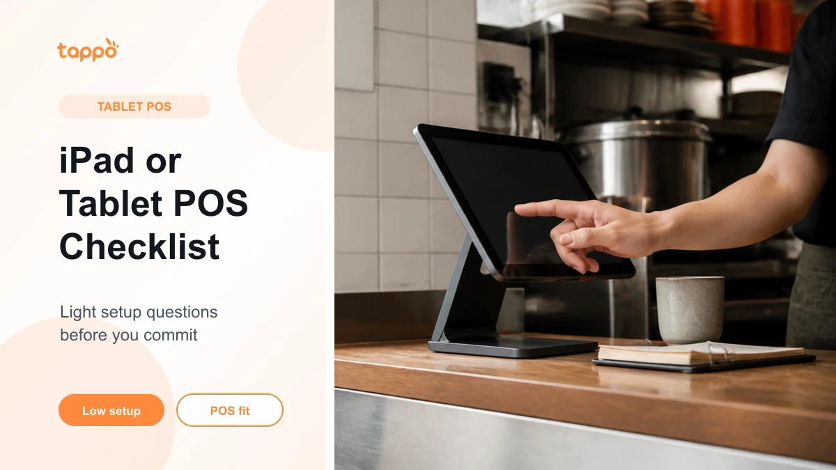 Tablet POS on a counter stand with an operator hand in a small restaurant